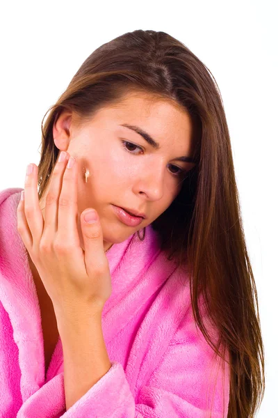 Woman applying moisturizer cream on her face — Stock Photo, Image