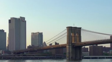 East River üzerindeki Brooklyn Köprüsü New York 'tan gün batımında Aşağı Manhattan' ın rıhtımından izlendi