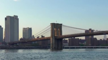 East River üzerindeki Brooklyn Köprüsü New York 'tan gün batımında Aşağı Manhattan' ın rıhtımından izlendi