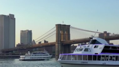 The Brooklyn Bridge over East River viewed from New York City Lower Manhattan waterfront at sunset