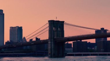 The Brooklyn Bridge over East River viewed from New York City Lower Manhattan waterfront at sunset