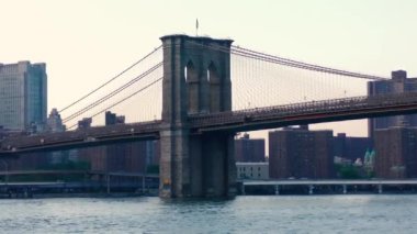East River üzerindeki Brooklyn Köprüsü New York 'tan gün batımında Aşağı Manhattan' ın rıhtımından izlendi