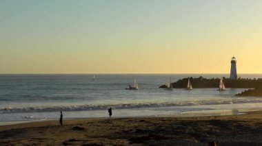 Günbatımında Twin Lakes Beach 'ten denize açılan yatlar, Santa Cruz, Kaliforniya, ABD, 2018