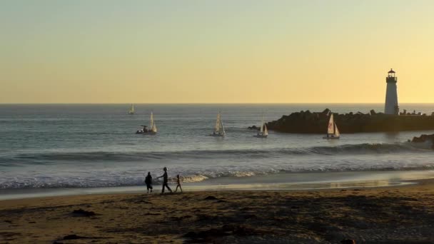 2018年米国カリフォルニア州サンタクルーズで日没時にツインレイクスビーチから見られるヨットをセーリング — ストック動画