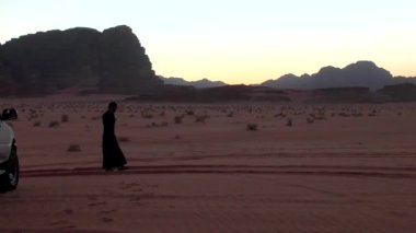 Ürdün Haşim Krallığı 'nda Wadi Rum Çölü' nde geleneksel giysiler içinde yürüyen Arap adam, aynı zamanda Ay Vadisi olarak da bilinir.