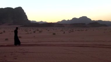 Ürdün Haşim Krallığı 'nda Wadi Rum Çölü' nde geleneksel giysiler içinde yürüyen Arap adam, aynı zamanda Ay Vadisi olarak da bilinir.