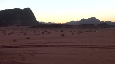 tourist cars driving in of Wadi Rum desert in the Hashemite Kingdom of Jordan, also known as The Valley of Moon