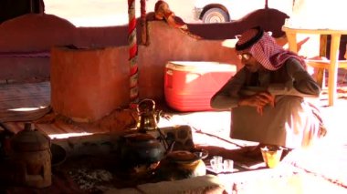 Ürdün 'ün Haşim Krallığı' ndaki Wadi Rum Çölü 'nde çadırda oturan geleneksel kıyafetli Arap bir adam, aynı zamanda Ay Vadisi olarak da bilinir.
