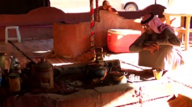 Ürdün 'ün Haşim Krallığı' ndaki Wadi Rum Çölü 'nde çadırda oturan geleneksel kıyafetli Arap bir adam, aynı zamanda Ay Vadisi olarak da bilinir.