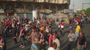 2019 'daki Irak protestolarında Irak hükümetine karşı gösteri yapan kimliği belirsiz kişiler, ayrıca 2019' da Bağdat 'ta Tishreen Devrimi veya Irak İntifadası olarak adlandırıldı.