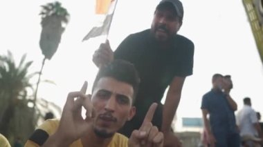 2019 'daki Irak protestolarında Irak hükümetine karşı gösteri yapan kimliği belirsiz kişiler, ayrıca 2019' da Bağdat 'ta Tishreen Devrimi veya Irak İntifadası olarak adlandırıldı.