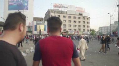 2019 'daki Irak protestolarında Irak hükümetine karşı gösteri yapan kimliği belirsiz kişiler, ayrıca 2019' da Bağdat 'ta Tishreen Devrimi veya Irak İntifadası olarak adlandırıldı.