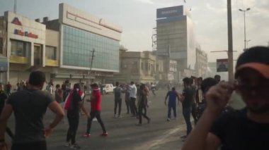 2019 'daki Irak protestolarında Irak hükümetine karşı gösteri yapan kimliği belirsiz kişiler, ayrıca 2019' da Bağdat 'ta Tishreen Devrimi veya Irak İntifadası olarak adlandırıldı.