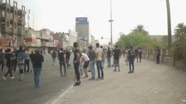 2019 'daki Irak protestolarında Irak hükümetine karşı gösteri yapan kimliği belirsiz kişiler, ayrıca 2019' da Bağdat 'ta Tishreen Devrimi veya Irak İntifadası olarak adlandırıldı.