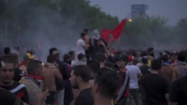 2019 'daki Irak protestolarında Irak hükümetine karşı gösteri yapan kimliği belirsiz kişiler, ayrıca 2019' da Bağdat 'ta Tishreen Devrimi veya Irak İntifadası olarak adlandırıldı.