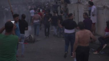 2019 'daki Irak protestolarında Irak hükümetine karşı gösteri yapan kimliği belirsiz kişiler, ayrıca 2019' da Bağdat 'ta Tishreen Devrimi veya Irak İntifadası olarak adlandırıldı.