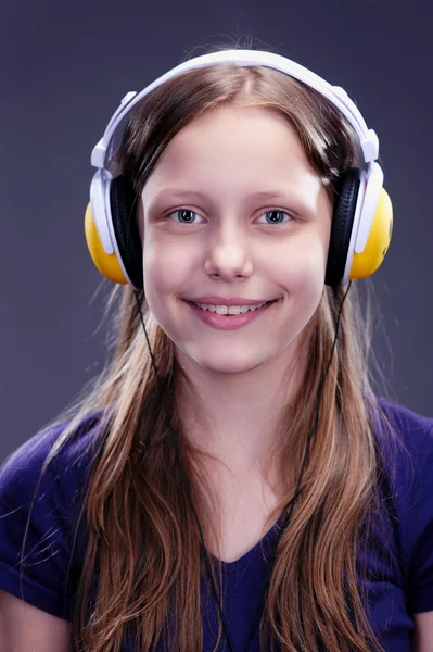 Detailní portrét smějící se dospívající dívka se sluchátky — Stock fotografie