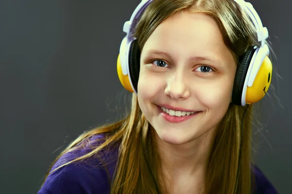 Closeup retrato de uma menina adolescente sorridente com fones de ouvido — Fotografia de Stock