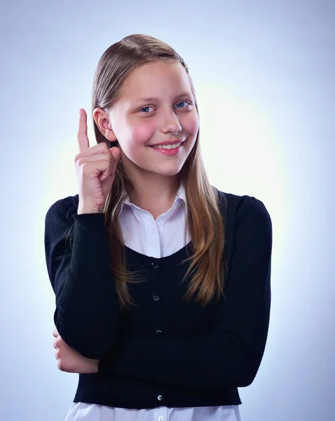 Portrait d'une adolescente souriante avec doigt vers le haut — Photo