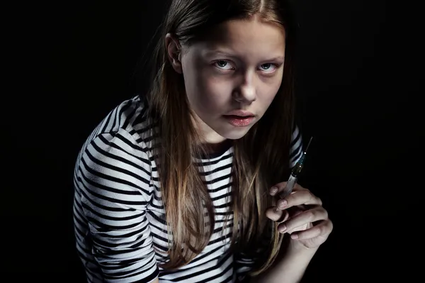 Dark portrait of a drug addicted teenager girl with syringe — Stock Photo, Image