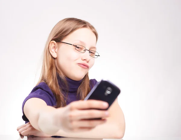 Портрет милой девочки-подростка с телефоном, делающей селфи — стоковое фото