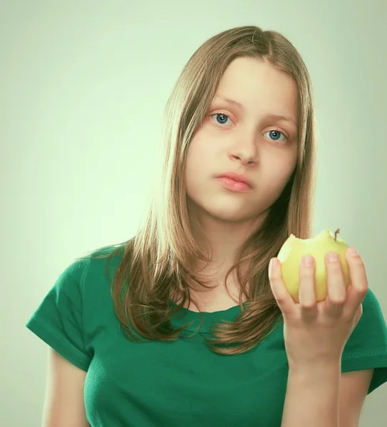 Portrait of an unhappyl teen girl with an apple — Stock Photo, Image