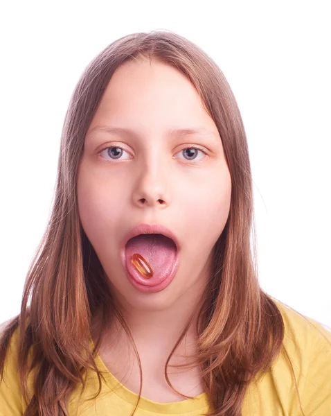 Ragazza adolescente con una pillola isolata su bianco — Foto Stock