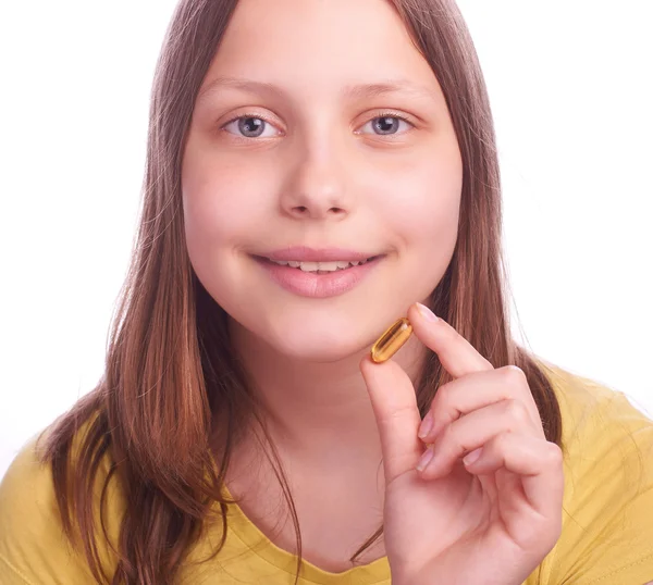 Ragazza adolescente con una pillola isolata su bianco — Foto Stock