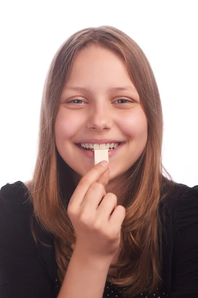 Menina adolescente comendo bubblegum no fundo branco — Fotografia de Stock
