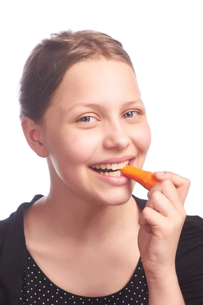 Ten girl eating carrot — Stock Photo, Image