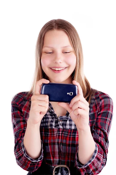 Счастливая девочка-подросток смеется и пользуется мобильным телефоном — стоковое фото
