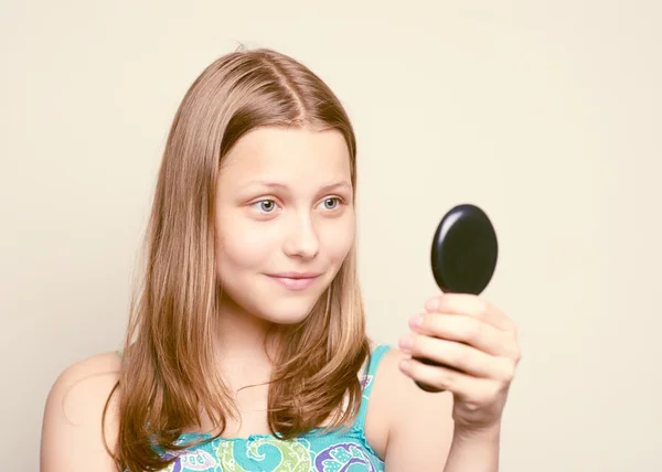 Девочка-подросток смотрит в зеркало — стоковое фото