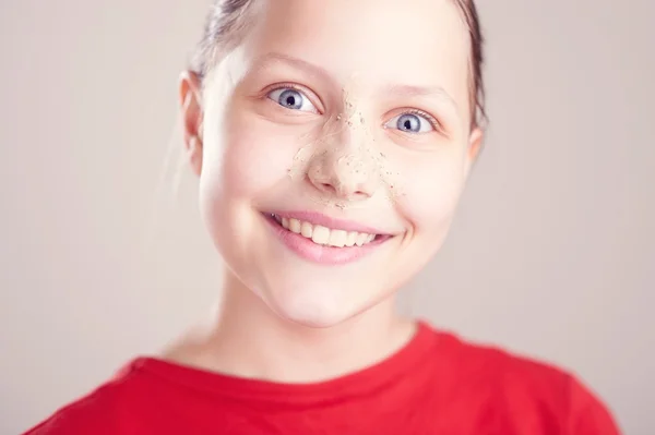 Felice ragazza adolescente con maschera scrub sul suo viso — Foto Stock