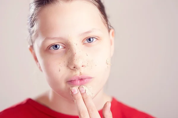 Joyeux adolescent fille avec masque gommage sur son visage — Photo