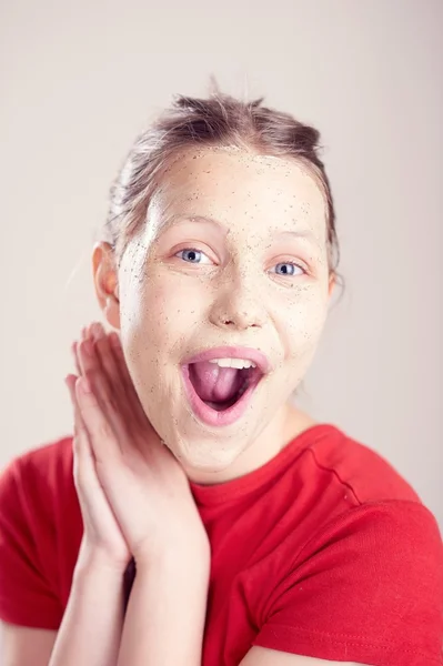 Joyeux adolescent fille avec masque gommage sur son visage — Photo