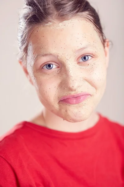 Joyeux adolescent fille avec masque gommage sur son visage — Photo