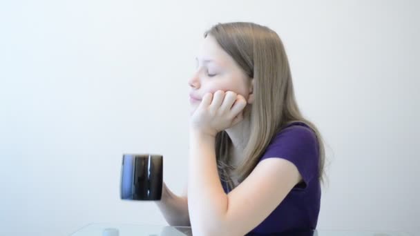 Teen girl drinking beverage from a mug — Stock Video