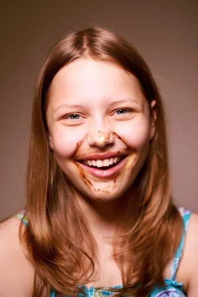 Tini lány arcán csokoládéval — Stock Fotó