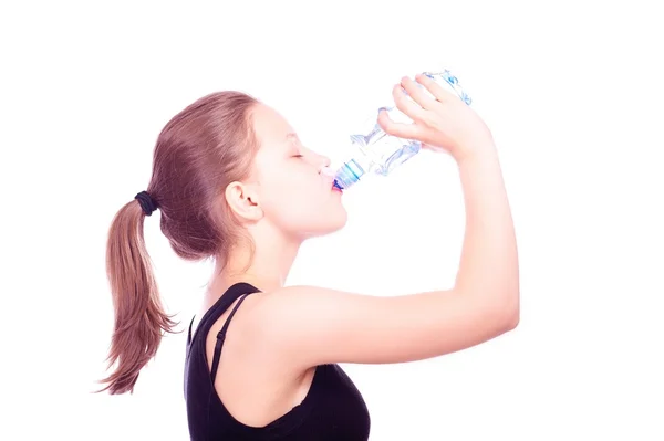 Дівчина-підліток п'є воду з пляшки — стокове фото