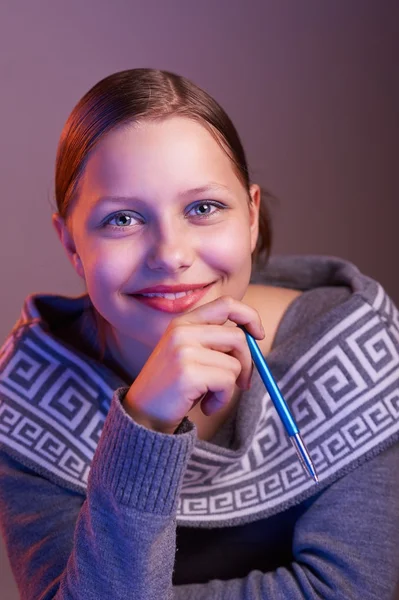 Ragazza adolescente sorridente con la penna in mano, ritratto — Foto Stock