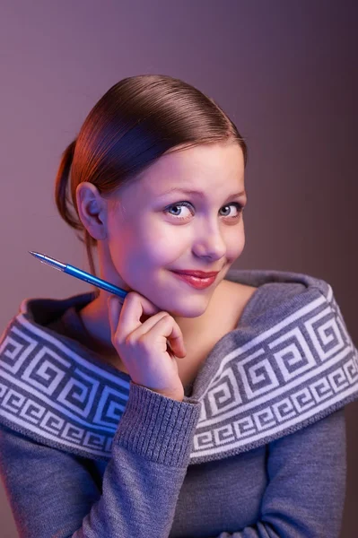 Teen girl smiling with pen in her hand, portrait — Stock Photo, Image