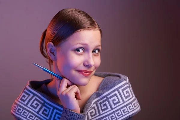 Chica adolescente sonriendo con la pluma en la mano, retrato — Foto de Stock