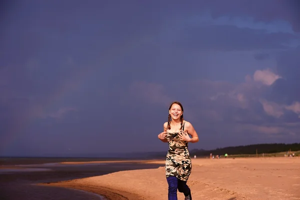 Adolescente court le long de la plage — Photo