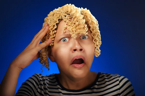 Шокированная девочка с макаронами вместо волос — стоковое фото