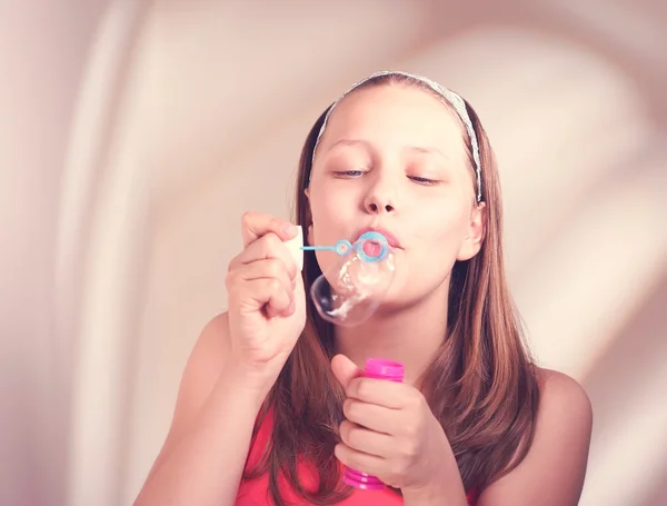 Happy teen girl blowing soap bubbles — Stock Photo, Image