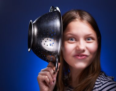 Teen girl holding colander and grimacing clipart