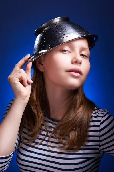 Calm teen girl with a colander on her head — Stock Photo, Image