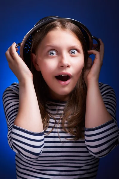 Surprised girl with a colander on her head — Stock Photo, Image