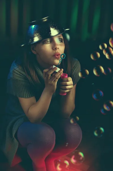 Sad teen girl sits and blows soap bubbles — Stock Photo, Image