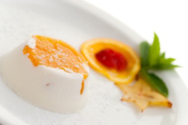 İtalyan tatlı panna cotta beyaz tabakta coconu ile dekore edilmiştir.